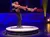 A man on roller skates spins a woman around on stage during a performance.