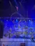 A performer balances atop a rotating circular apparatus on a stage with a winter-themed backdrop.