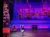 A performer is doing a handstand on a stage with a colorful, snowy village backdrop.