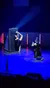 A performer is emerging from a mysterious box on stage with an acrobatic pose while another looks on, amidst atmospheric stage lighting.