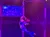 A performer is gracefully suspended mid-air, illuminated by colorful stage lights.