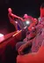 A performer on stage is pulling an audience member up by the hand while others watch attentively.