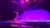 A performer skillfully spins multiple hoops on stage under colorful spotlights.