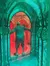 A person is navigating through an elaborately decorated, colorful mirror maze.