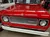 A vintage red 1969 International Harvester vehicle is displayed in a well-lit showroom with vintage memorabilia.