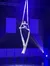An aerial performer is demonstrating a skillful pose on hanging silks against a starry backdrop illuminated by theatrical lighting.