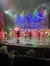 Performers, including someone dressed as Santa Claus, are taking a bow on stage in a festive-themed show.