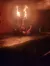 The image displays a dimly lit performance area where a person appears to be executing a dangerous fire stunt with their legs raised and engulfed in flames, while being surrounded by a safety net.