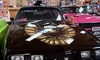 The image shows a 1979 Pontiac Trans Am in a museum or showroom, surrounded by automotive memorabilia.