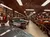 The image shows an indoor car museum displaying a collection of vintage cars with memorabilia adorning the walls.