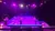 Three performers are on a brightly lit stage with hoops, set against a backdrop of stairs and purple lighting.
