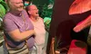 Two people are enjoying a visit to a museum exhibit featuring a large dinosaur.