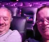 Two people are sitting in a mostly empty theater, smiling at the camera.