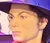 A visitor is posing next to a wax figure that resembles a famous pop star, standing in a distinctive dance pose within an enclosed area with mirrored walls.