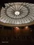 This image shows the ornate ceiling of an elegant interior space, likely a theater or an old building, with a large, intricate chandelier hanging from the center and a date stamp indicating