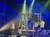 Performers on stage are engaging with the audience amid dynamic lighting during a live show or concert.