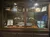 The image shows a glass-front display cabinet containing a variety of maritime memorabilia, including model ships, an American flag, a captain's hat, trophies, and framed certificates or photographs.