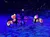 Horses with butterfly wing costumes are being paraded in an illuminated arena, creating a magical and whimsical display.
