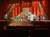 The image depicts a live stage performance featuring dancers and musicians possibly part of an Irish-themed show.