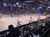 The image depicts a patriotic scene with horse-riding performers carrying American flags in an indoor rodeo arena while an audience watches.