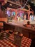 Performers entertain an audience in a rustic, wooden staged area with a country or folk ambiance.