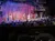 A group of performers is on stage in a rustic, barn-like setting, engaging an audience in a dinner theater atmosphere.