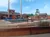 The image shows an outdoor lumberjack-themed entertainment venue with various lumberjack sport activities including log rolling and axe throwing areas.
