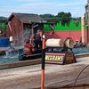 A lumberjack-themed show with participants engaging in a log rolling competition causing a splash in the water.