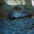 An octopus is partially concealed behind a rock in its aquatic environment.