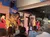 Performers in western attire are on a stage set up to resemble an old Western town, engaging an audience in a theatrical performance.