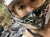 Two individuals wearing helmets are posing for a selfie while enjoying an outdoor adventure with an ATV.