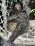 A sloth is resting in a hammock with its arms folded, appearing relaxed and cozy.