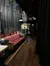 This image shows a backstage area with technical equipment, including a lighting control board and a variety of cables, alongside a red couch, presumably within a theater or performance venue.