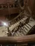 An ornate wooden staircase with visitors in various stages of ascent and descent adds a lively element to the grand interior setting.