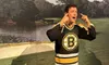 A person is standing in front of a background depicting a golf course, wearing a Boston Bruins hockey jersey, and making a comical gesture with their hands pulling down on their face to stretch their eyes wide open.
