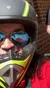 Three people wearing helmets are posing for a selfie with a clear blue sky in the background, seemingly preparing for or returning from a ride on recreational vehicles.