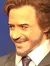 A person is posing with wax figures of celebrities at a wax museum.