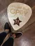 A person is standing on a large guitar pick-shaped floor emblem with