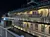The image shows a multi-level riverboat at night, illuminated by decorative lights, with a gift shop and various other rooms visible through its windows.