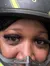 A person wearing a helmet takes a selfie during a break in an off-road ATV adventure in a dusty, forested area.