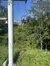 A chairlift carries passengers over a lush green hillside on a sunny day.