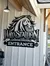 The image shows a black and white sign with a stylized horse head graphic titled 