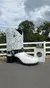 A large, decorative cowboy boot sculpture stands outdoors with a cloudy sky in the background.