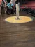 The image shows the interior of a venue with a circular wooden stage marked