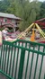 The image shows visitors enjoying a spinning ride at an amusement park, with a branded sign for