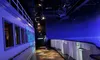 The image shows an indoor space with a dimly lit corridor featuring an atmospheric blue starry sky effect on the walls and ceiling, along with a person standing at the far end near an exit sign.