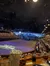 The image shows the interior of a large dinner theater with an arena-style seating arrangement focused around a central stage set up to look like a winter scene, with spectators seated and waiting for the performance to begin.