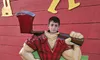 A person is posing through a cutout of a cartoon-style lumberjack figure at what appears to be an entertainment venue called