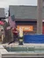 A person dressed in a red plaid shirt and jeans is theatrically chopping wood on a stage with an American flag in the background, at an event sponsored by STIHL.