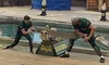 Two competitors engage in a log rolling contest at a lumberjack-themed event, with festive decorations and spectators in the background.